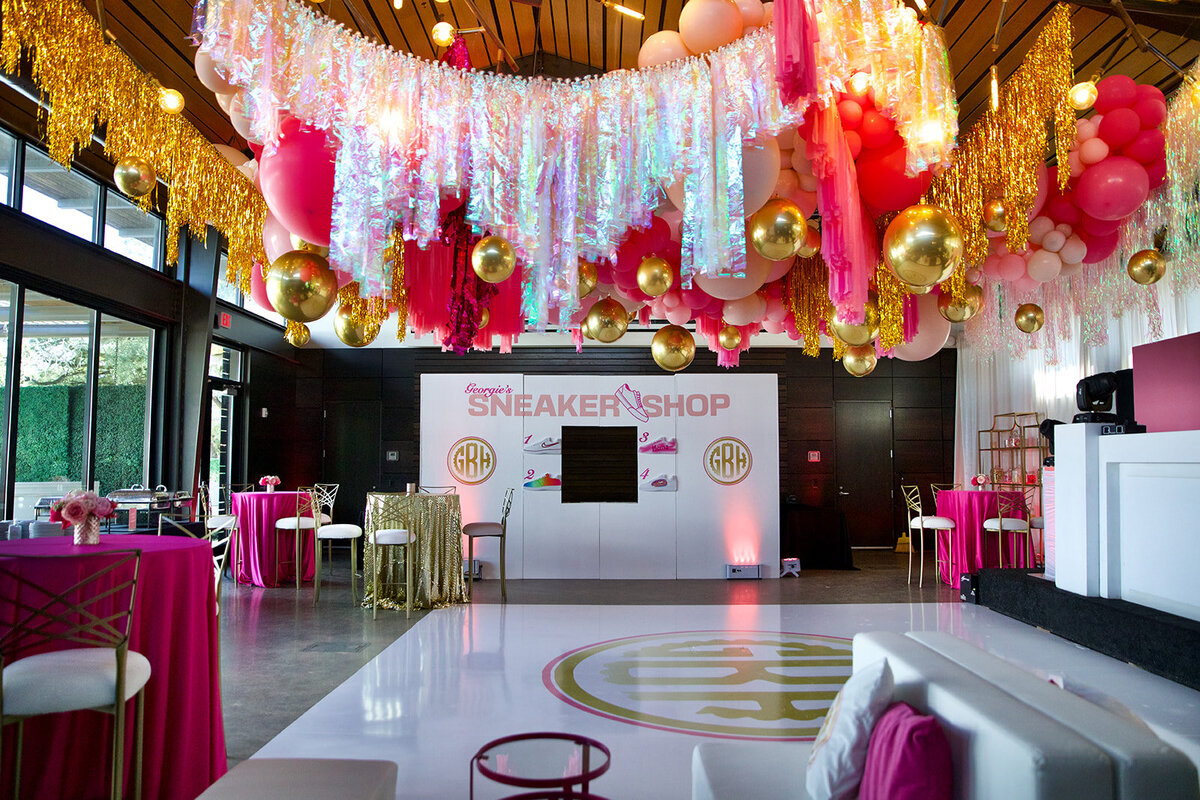 Pink and gold Bat Mitzvah party decorations with disco balls, streamers and a custom backdrop design