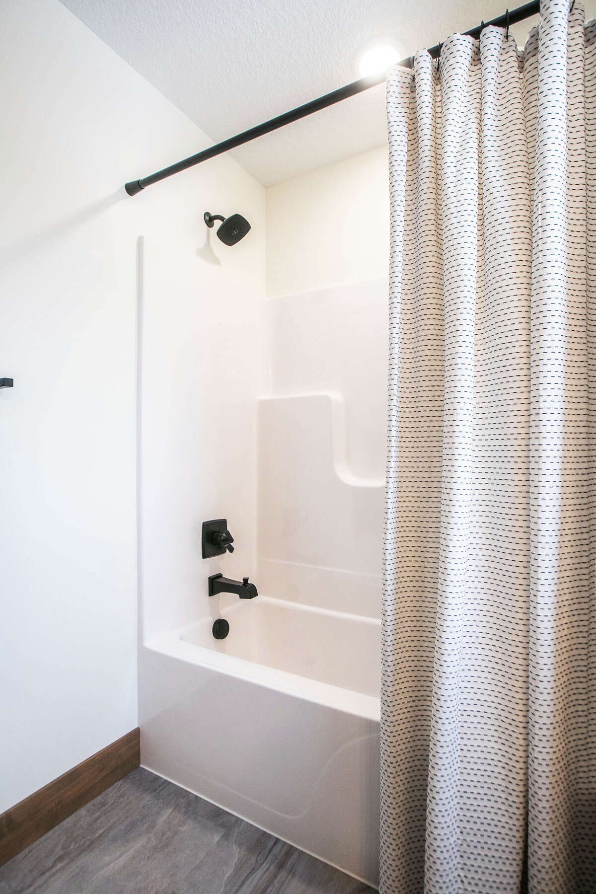 Custom bathroom with dark cabinets, shower and modern accents in Elk River home by Cornerstone Custom Builds