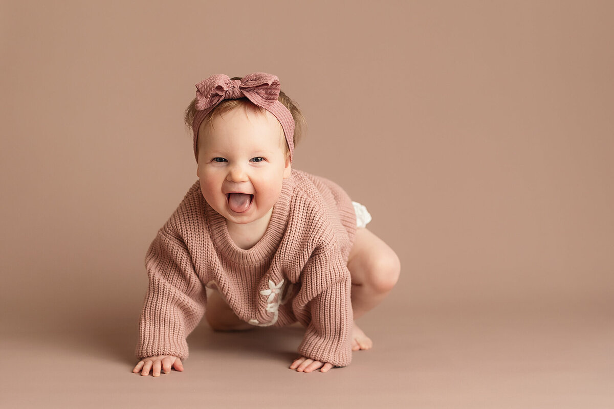 Sweet infant girl smiling during her milestone photo session in Mankato, Minnesota.