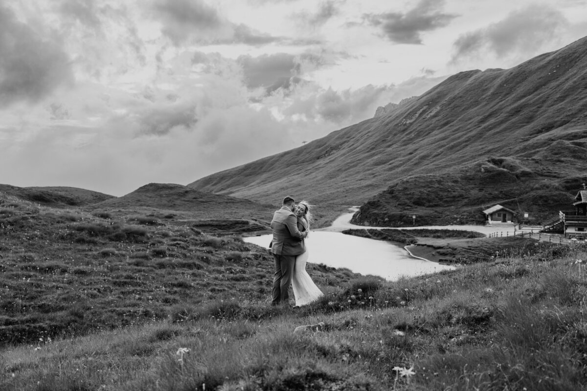 Couple embracing beside alpine lake in the Dolomites