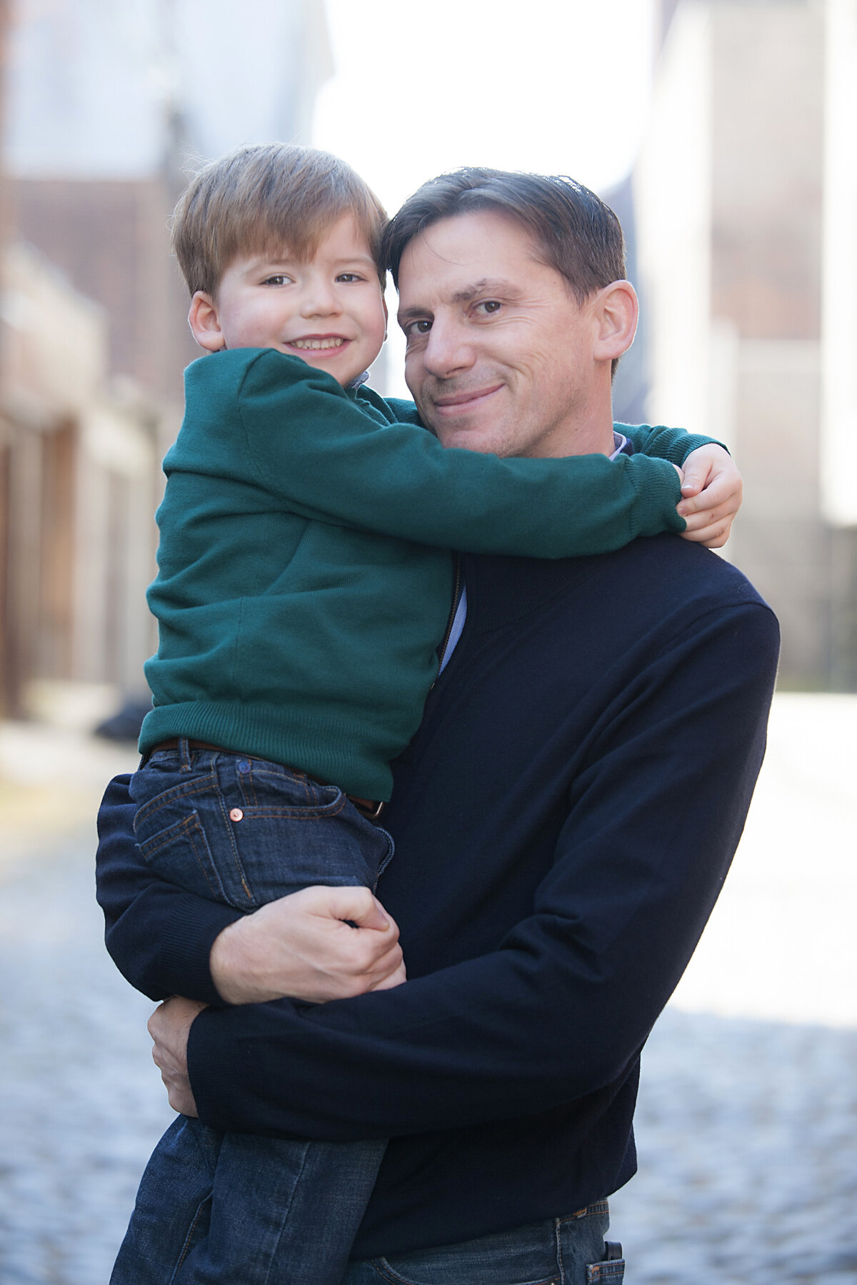 A parent holding their child as they both smile 