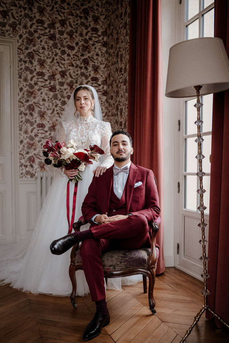 Portrait élégant d’un couple de mariés en hiver au Château de Nainville-les-Roches, dans une ambiance feutrée et chaleureuse.
