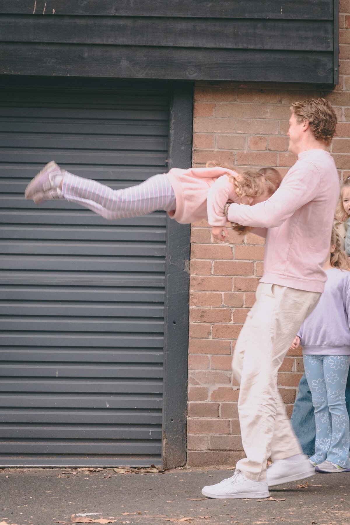 innercity-family-play-redfern-dad-swing-brickwall-photo