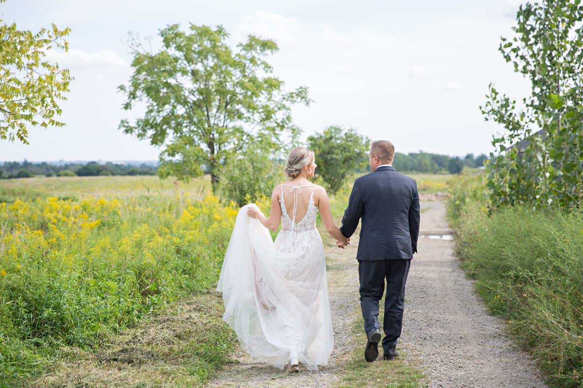 bride and groom walking down path from behind at Earth to Table Farm