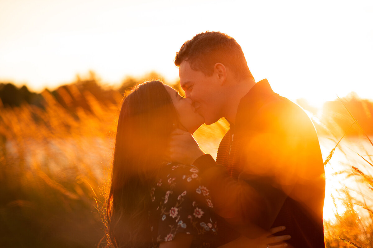 engagement-session-sunset-kissing-outdoors-pond