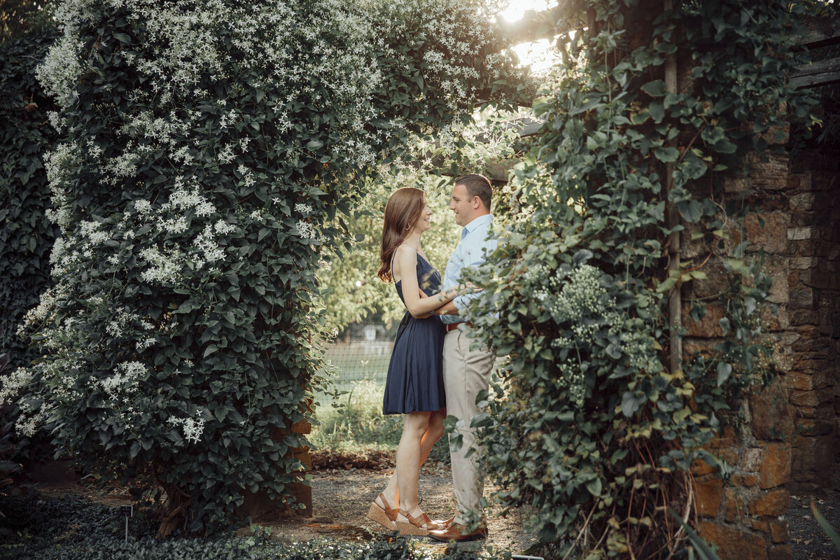 Couple embracing at sunset during engagement photo at Cross Estate Gardens in Bernardsville New Jersey