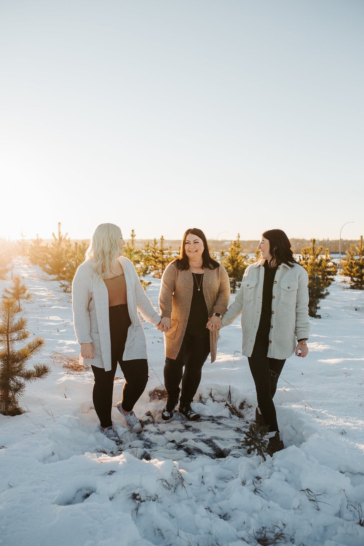 mom and daughters walking together in the snow