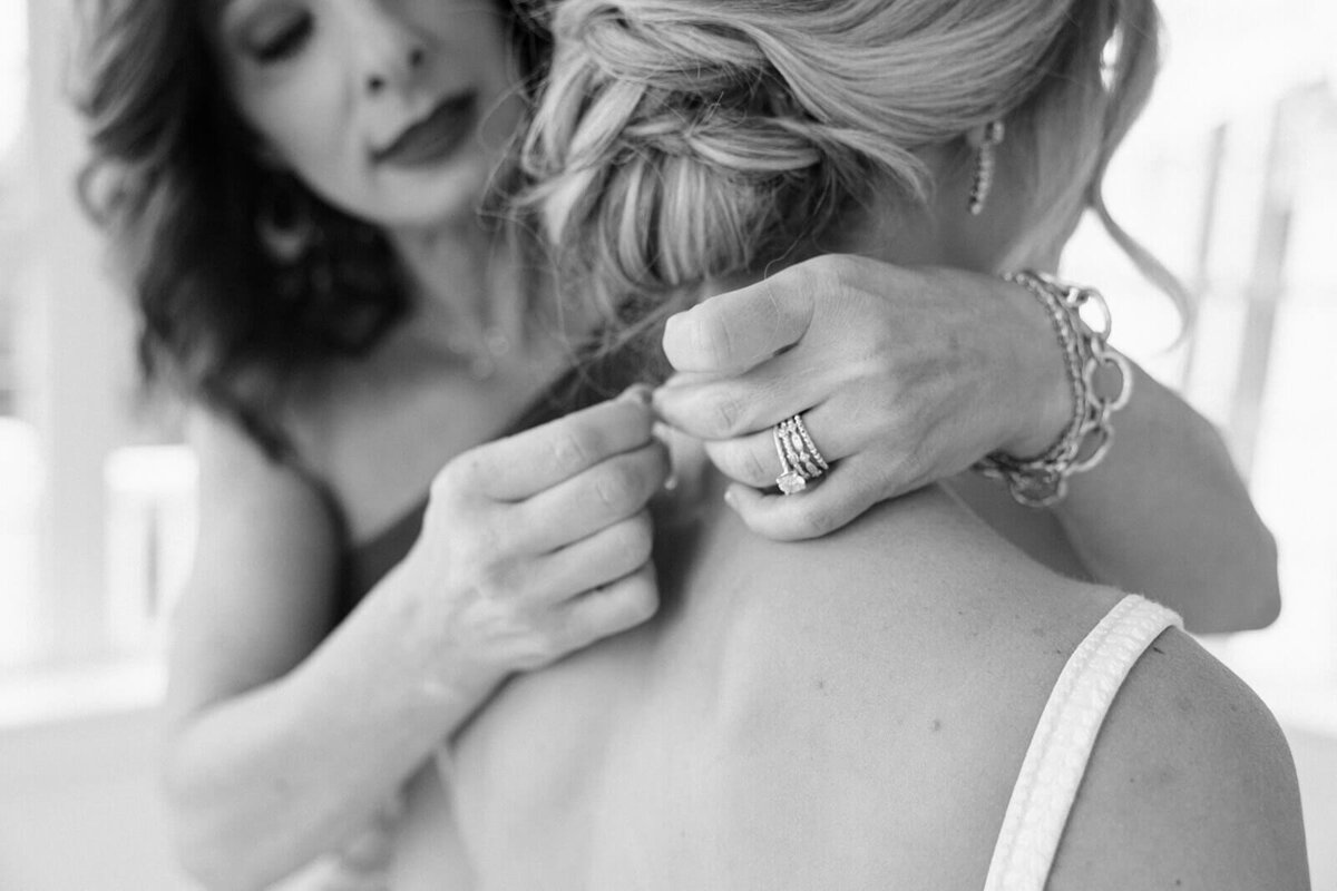 Bride having necklace put on