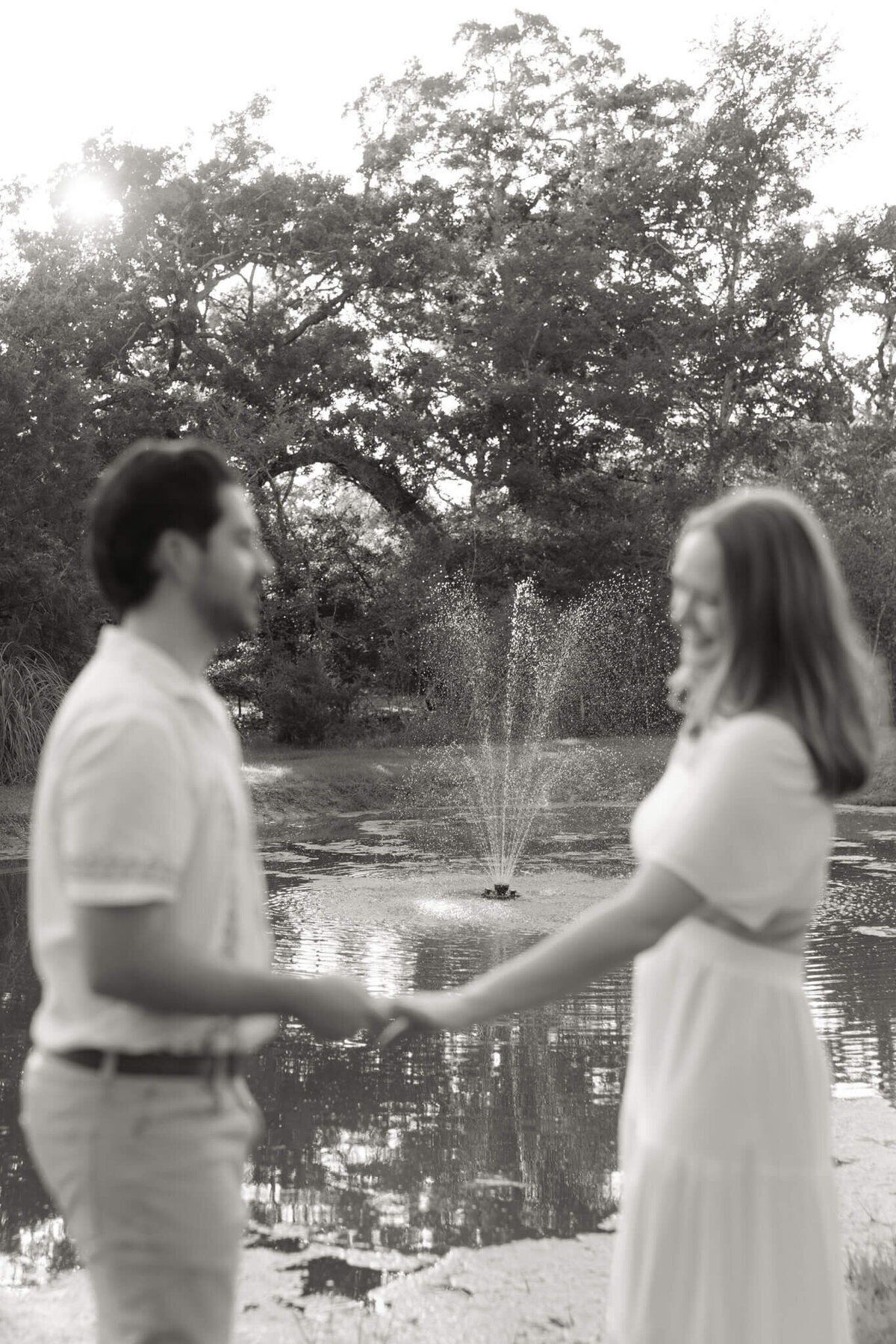 couple holding hands with a fountain in the background