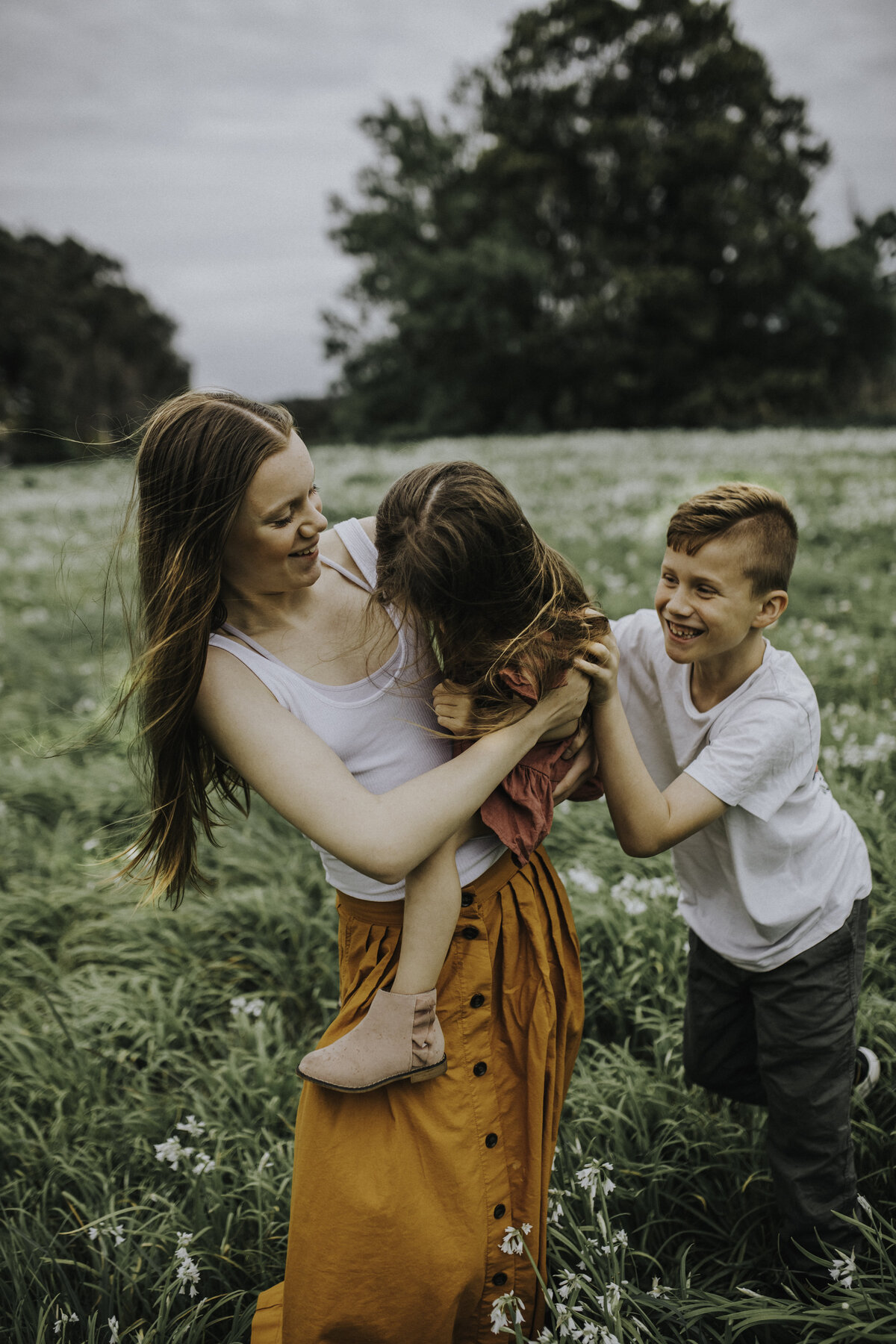 Candid fun photo of family kids playing laughing in field for Melbourne Family Lifestyle Photography Session with Sapphire and Stone Photography