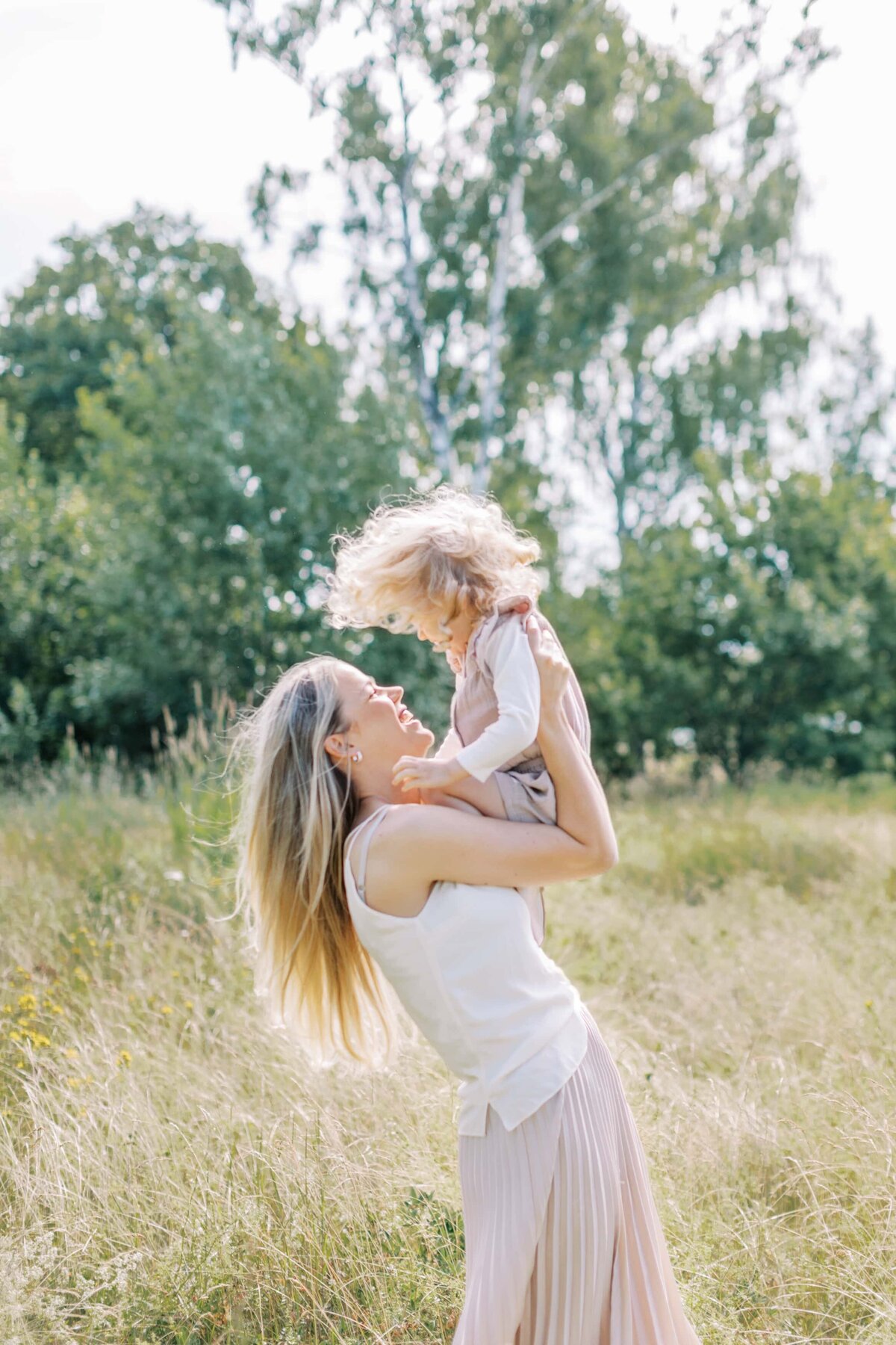 En solig mamma och dotter fotografering på en sommaräng