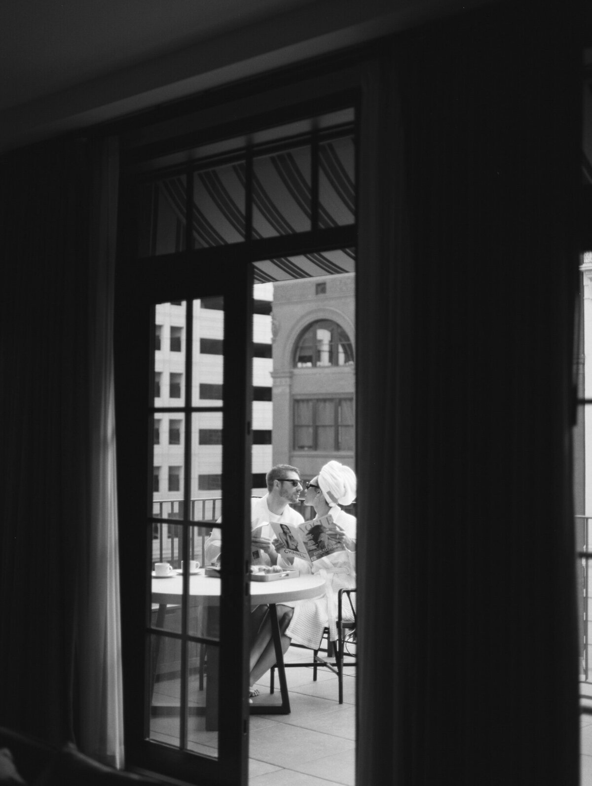 couple in bathrobes share brunch on hotel balcony at Shinola Detroit