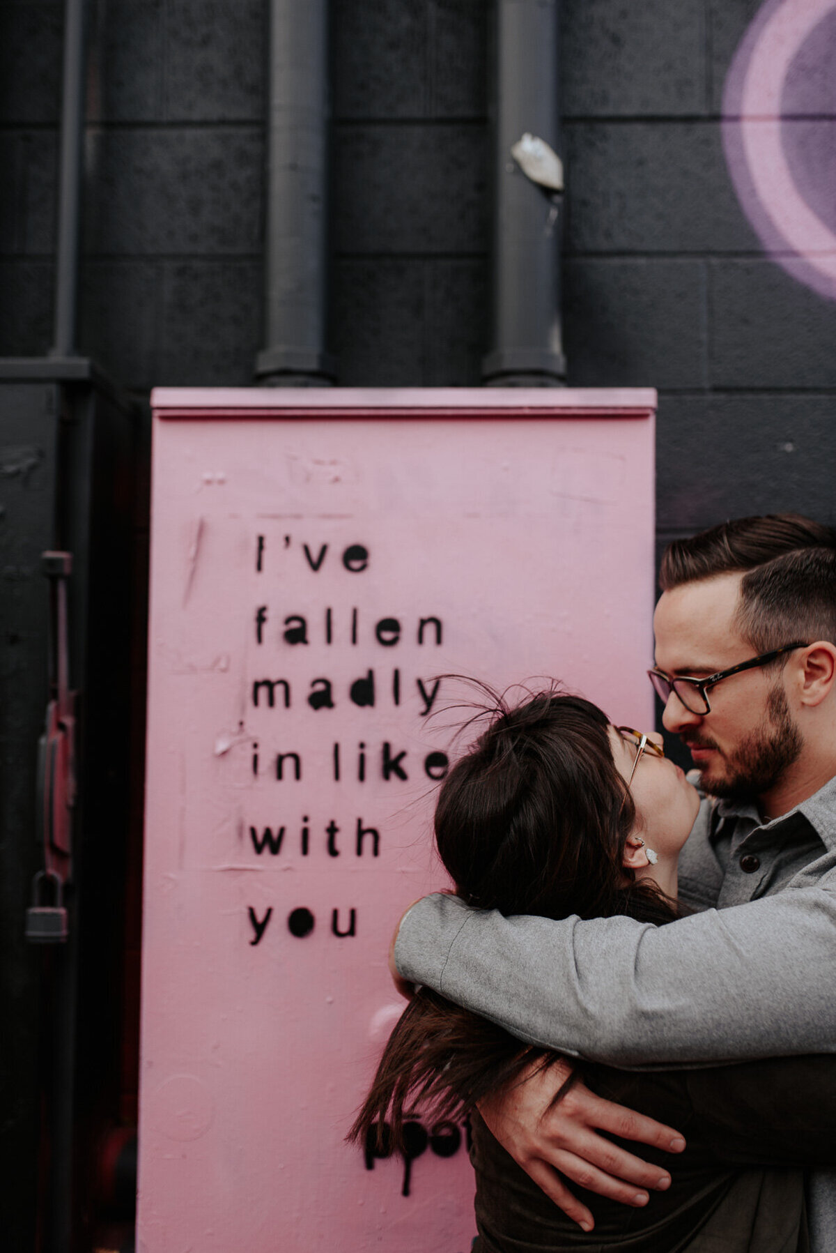 Couple photographed next to art installment that says Ive Fallen Madly in like with you