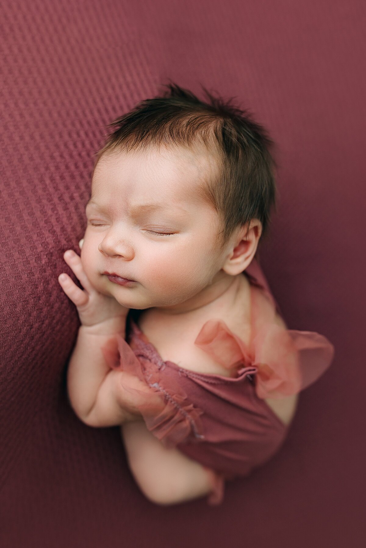 Studio newborn photography of baby girl on pink