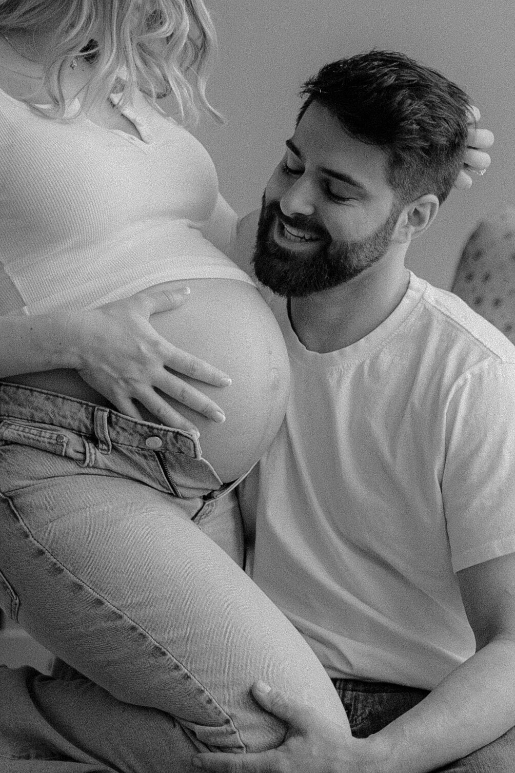 Man looking at woman's bump at at Finger Lakes maternity session