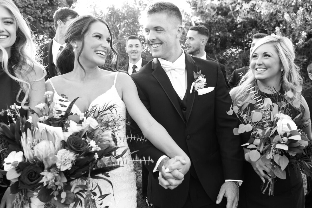 Bride and groom walking excitedly hand in hand. 