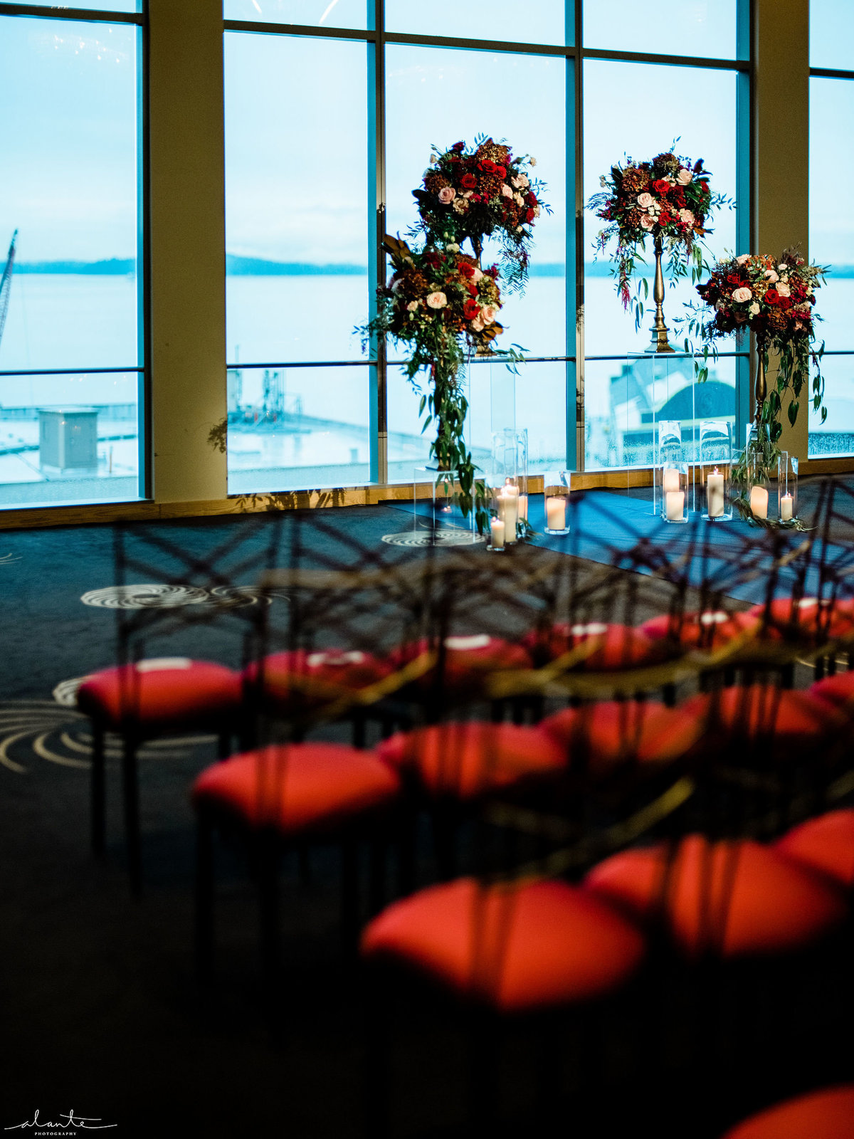 wedding ceremony flowers in deep red with red chairs