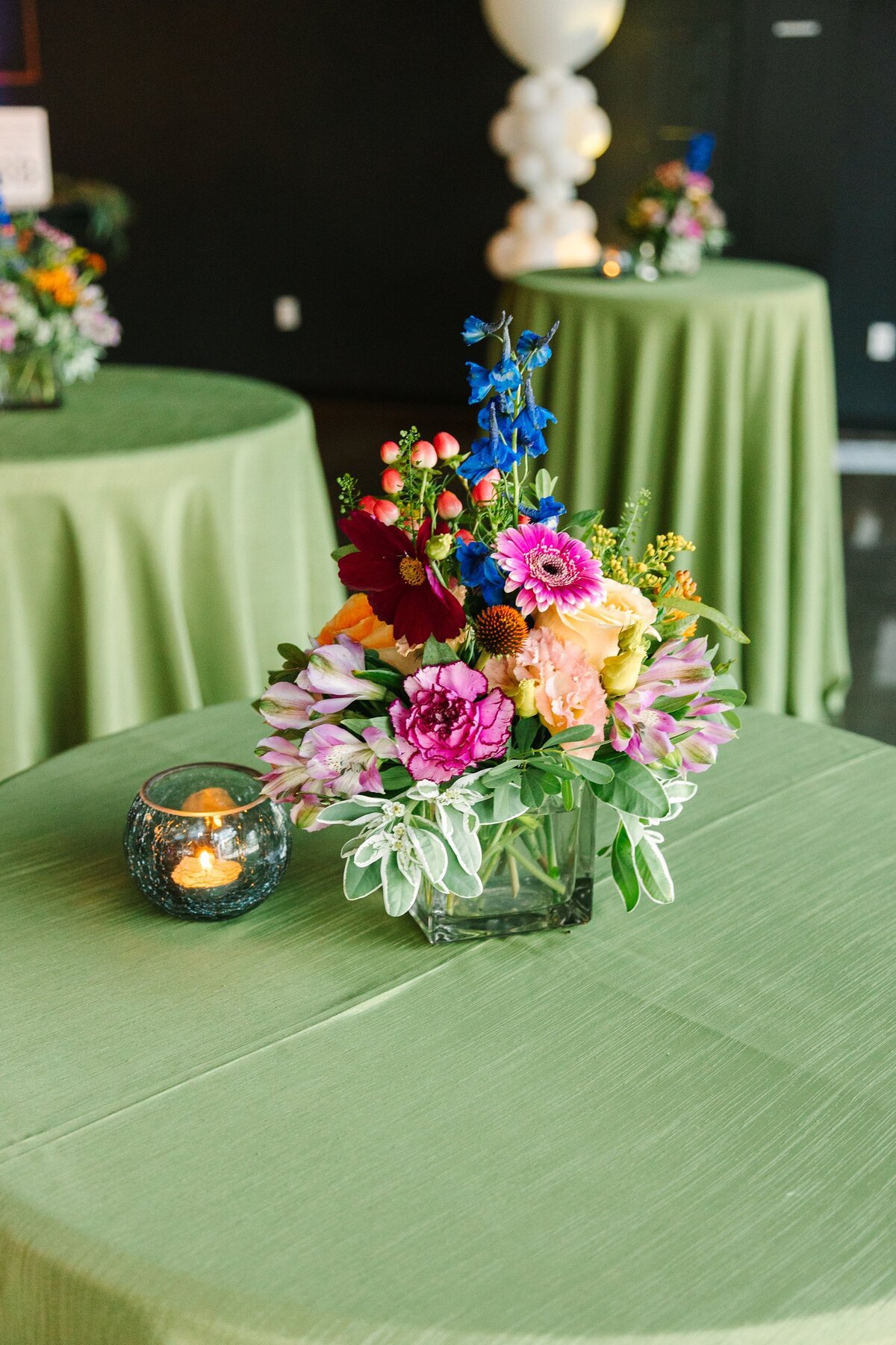 Green linens and colorful flowers cocktail hour