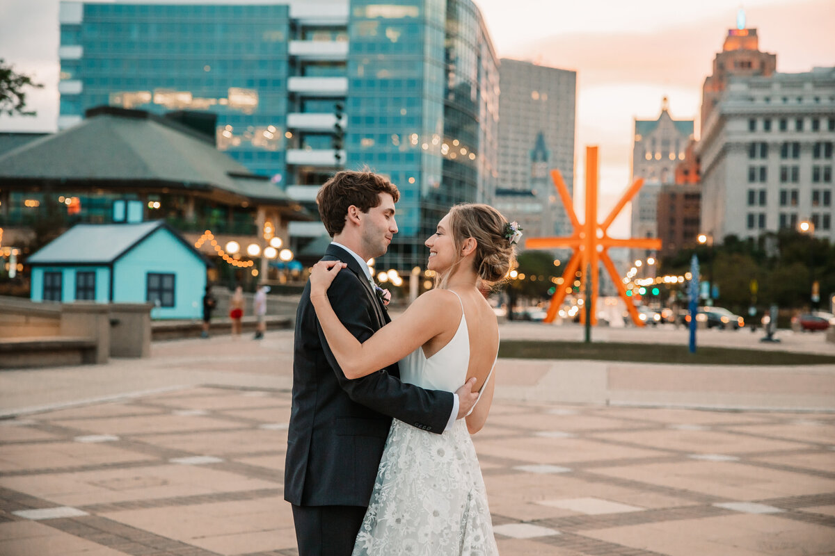 Newlyweds Dance in the courtyard at sunset in downtown