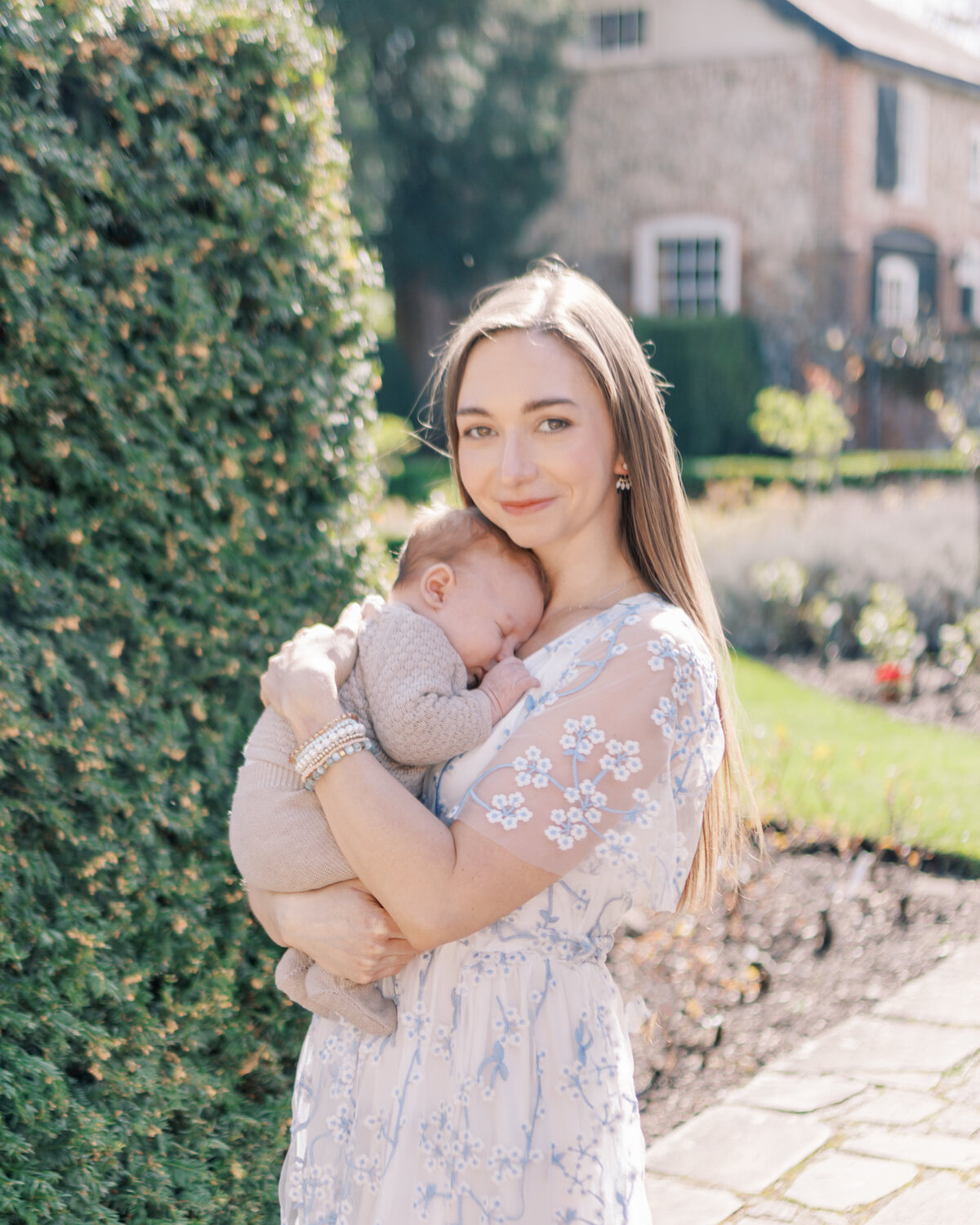 Mother holding newborn baby in gardens by Oklahoma City Photographer Courtney Cronin