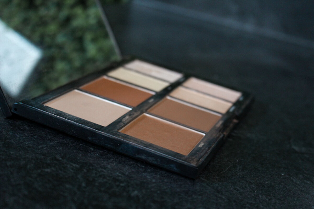 An open bronzer and highlight makeup palette