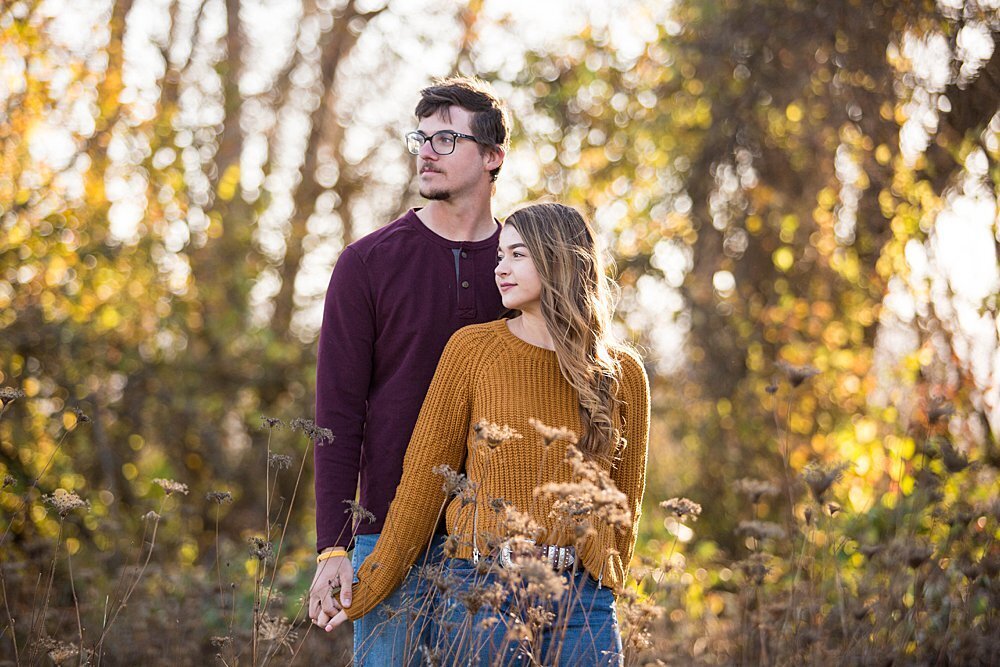 Romantic couple holding hands in Autumn with colorful trees