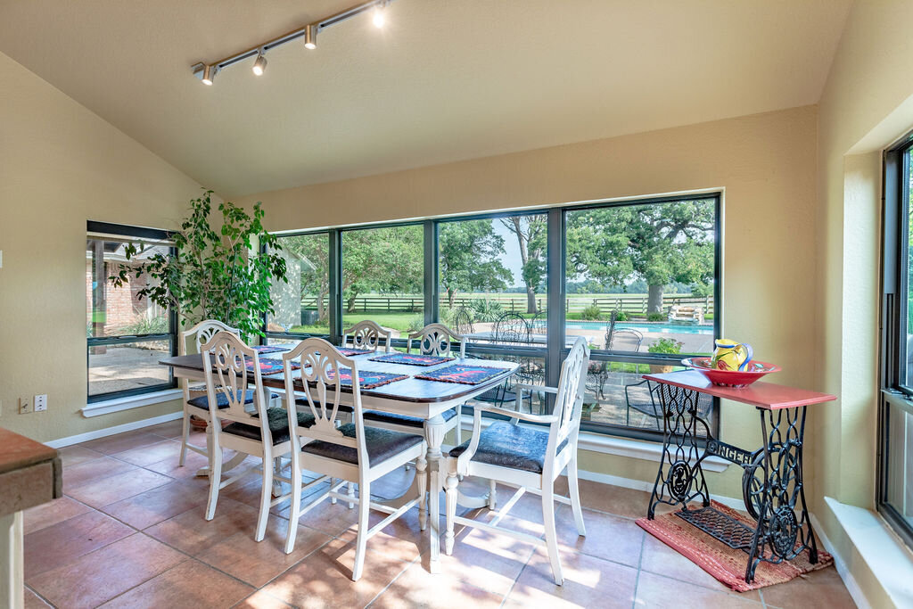 Dining table that seats six with a beautiful pool view in this 5-bedroom, 4-bathroom vacation rental house for 16+ guests with pool, free wifi, guesthouse and game room just 20 minutes away from downtown Waco, TX.