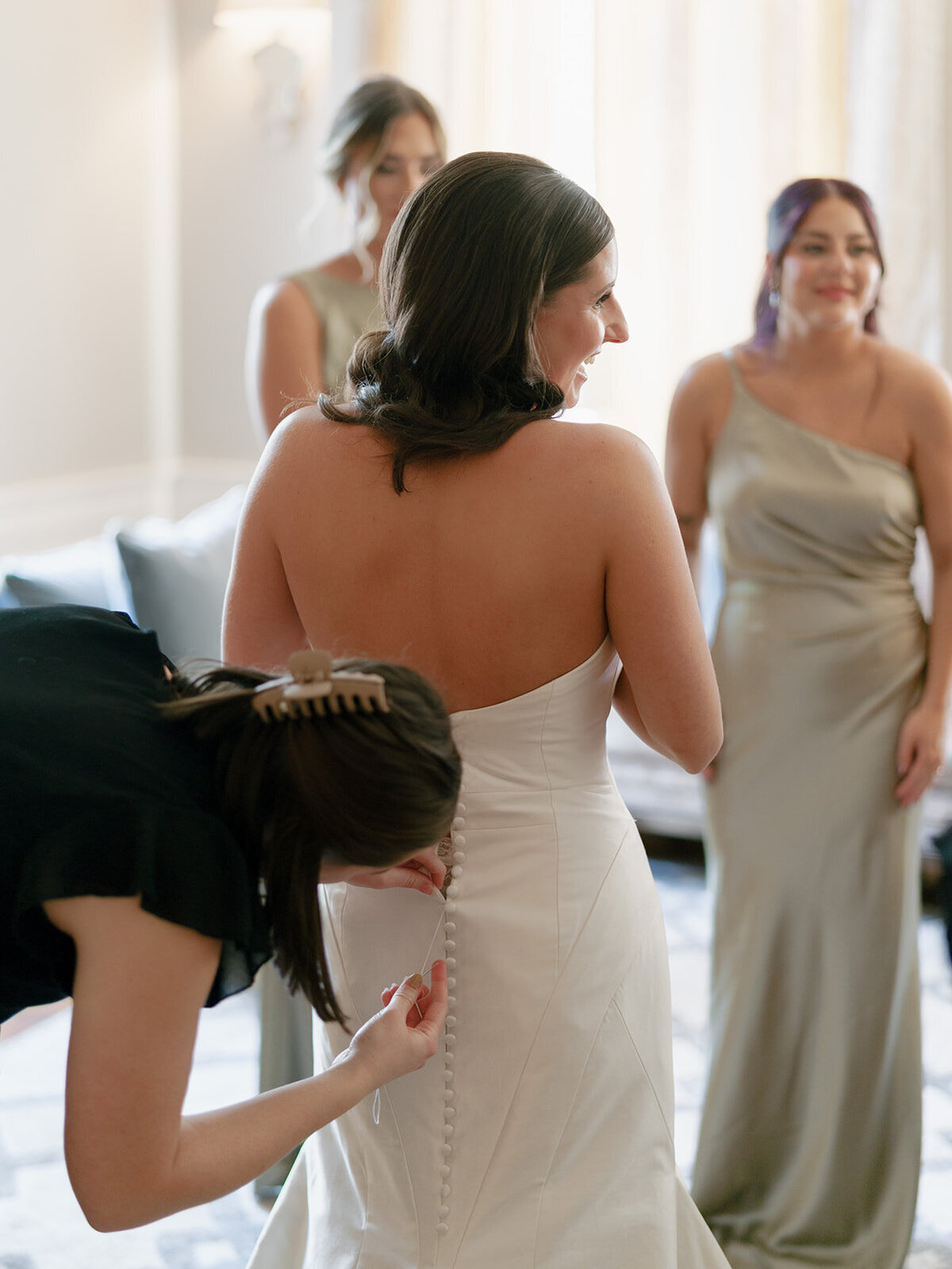 bride getting wedding dress fixed by wedding planner