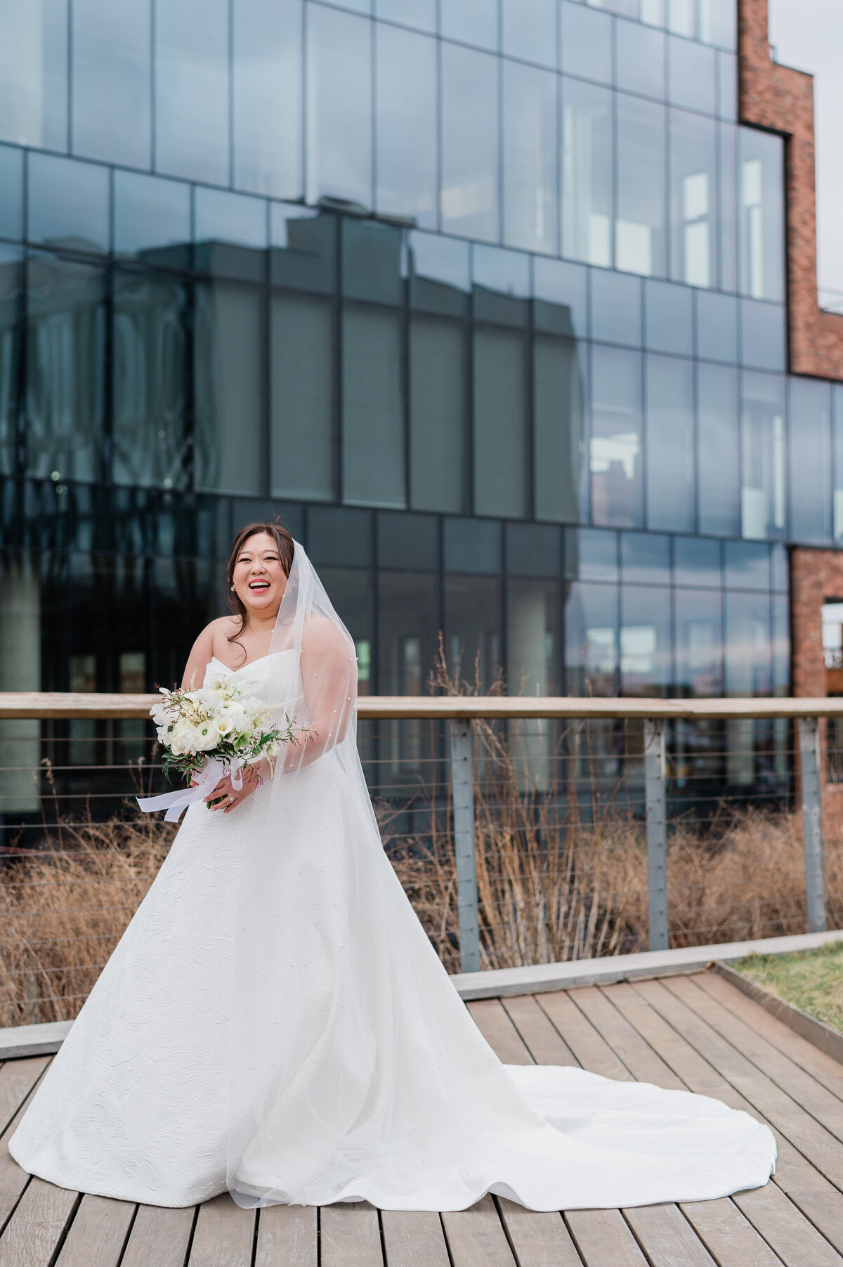 Bride smiles and holds her bouquet in front of her waist