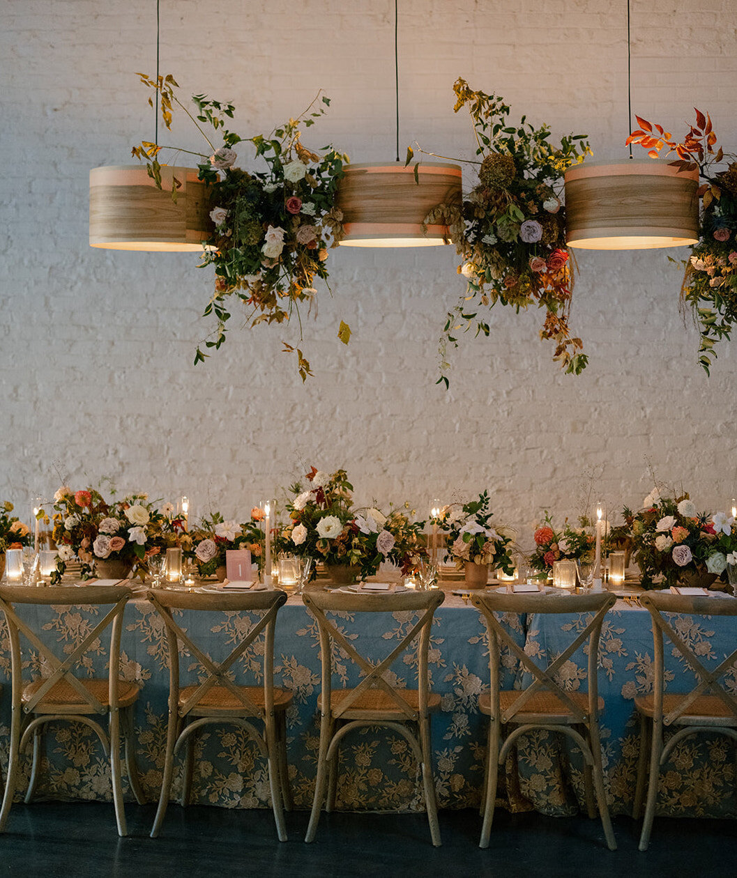 Floral Chandelier hanging floral clouds accent fall wedding reception in Raleigh, NC with roses, hydrangeas, and fall branches in colors of mauve, copper, cream, dusty pink, and green. Design by Rosemary and Finch Floral Design in Nashville, TN.