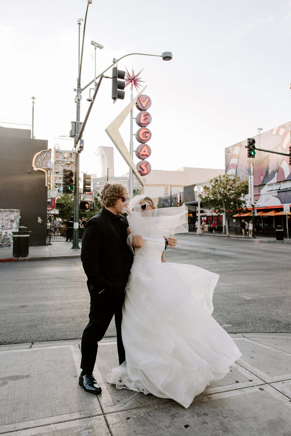 A couple poses in front of a classic Vegas sign.