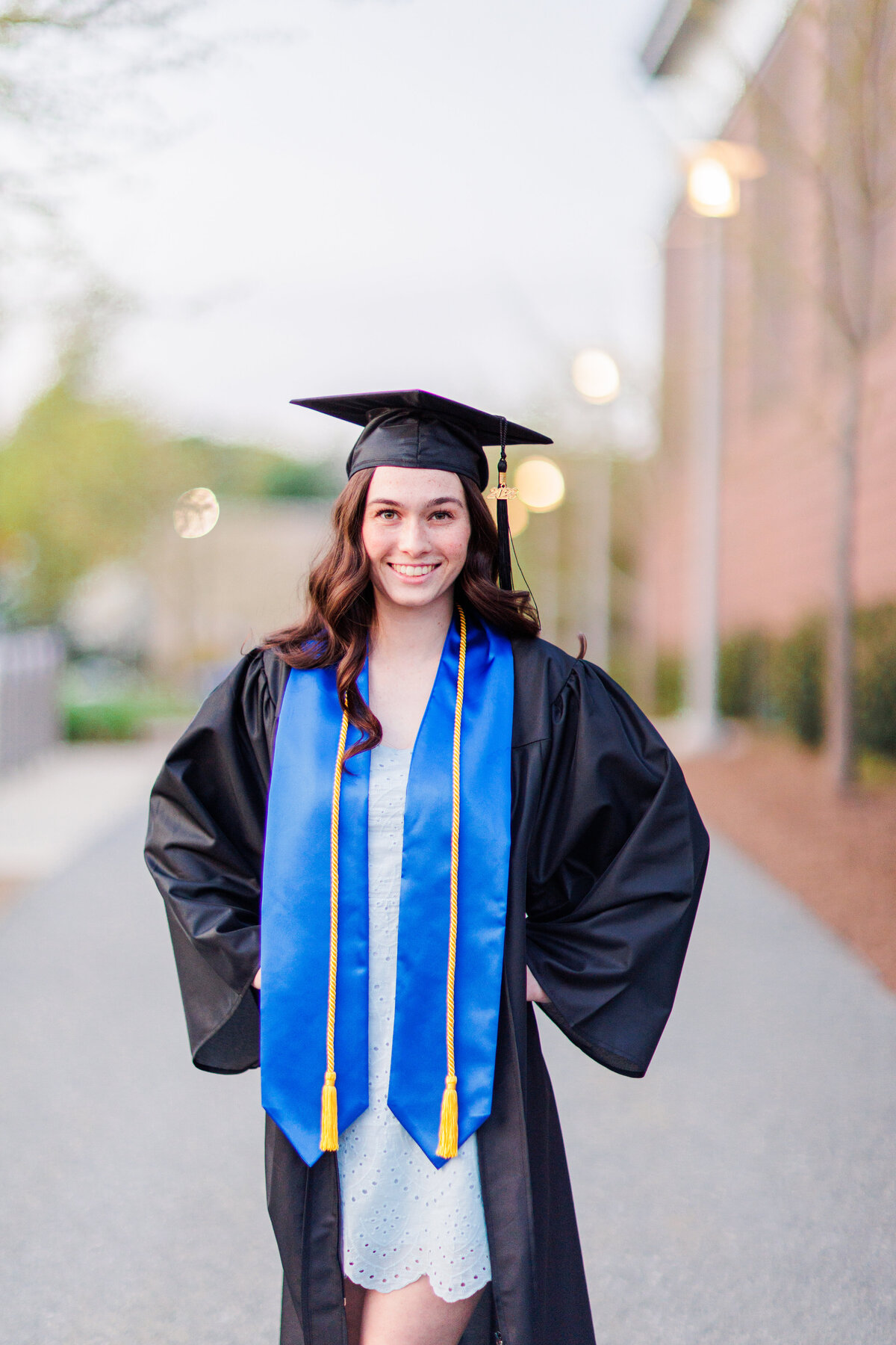 A girl posing wearing her graduation cap and gown representing Boston senior photography