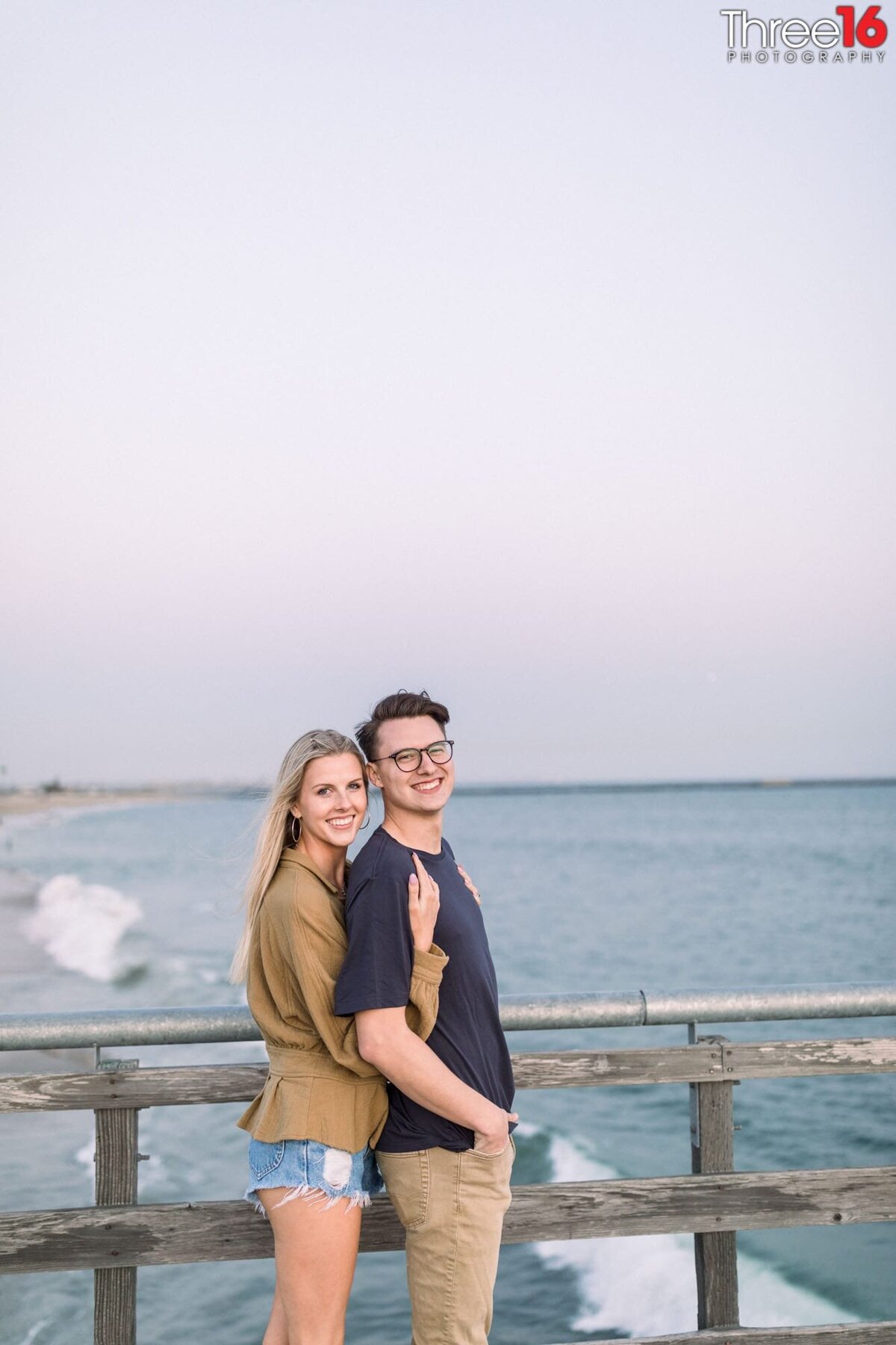 Bride to be holds her fiance from behind during engagement photo session