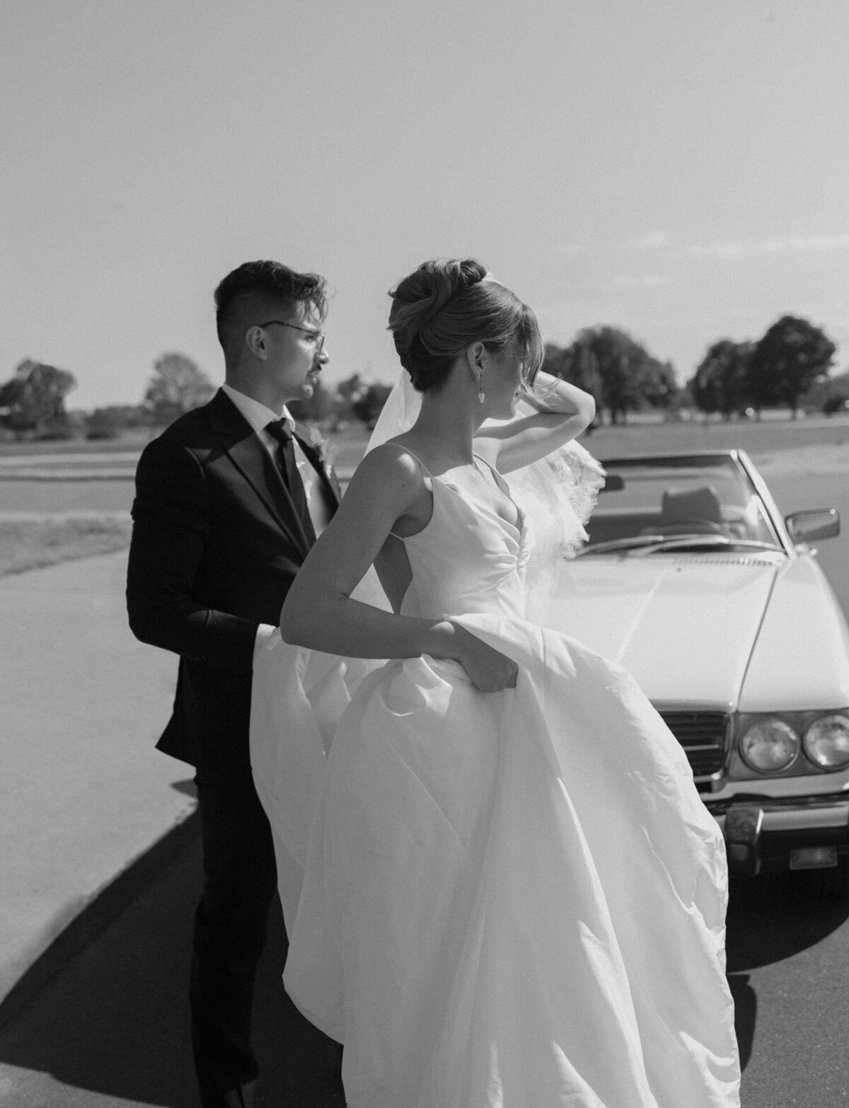 Stylish bride and groom exit vintage mercedes wedding convertible on Belle Isle, Detroit