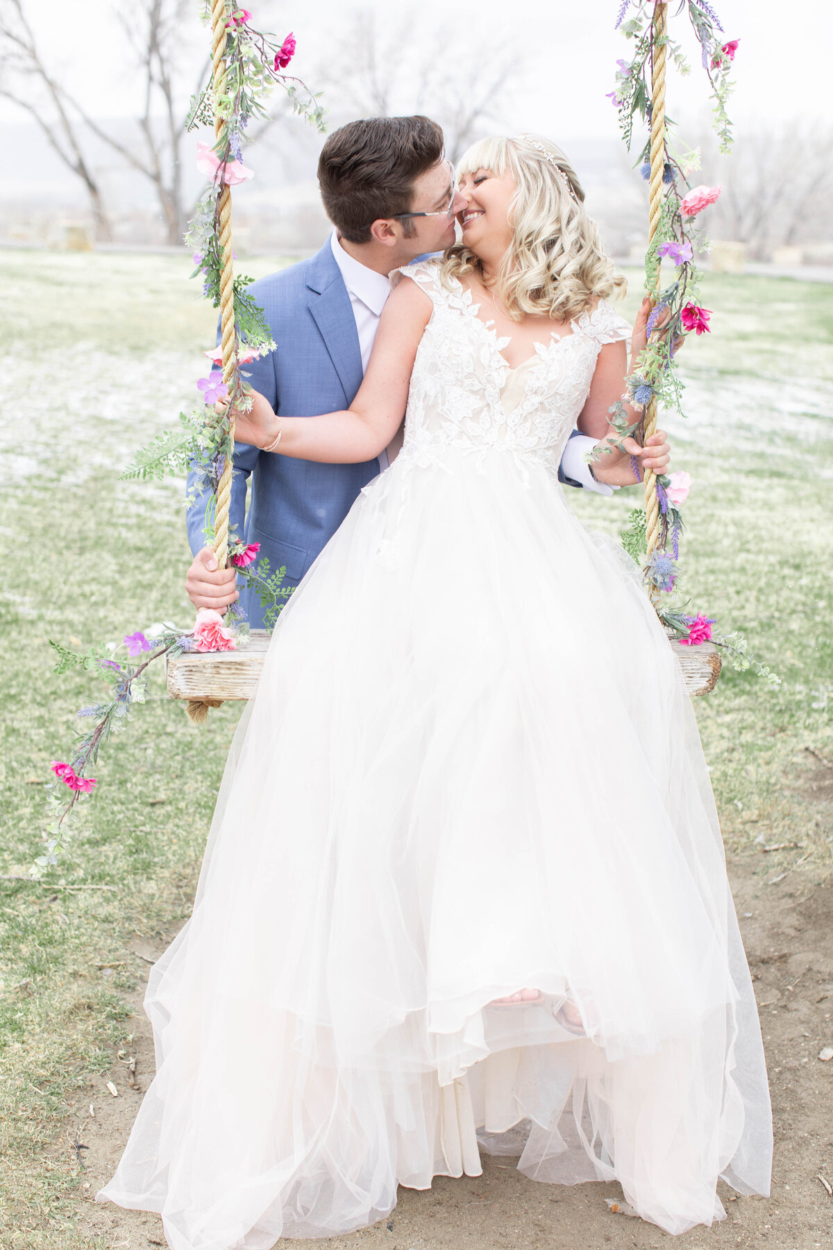 bride and groom wedding portrait taken on a swing at the camelot ranch wedding venue in billings