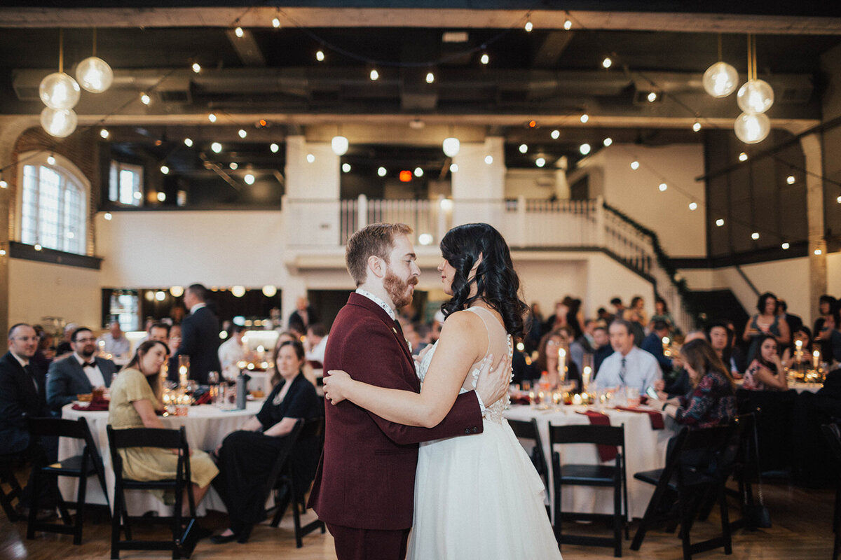 Bride and groom having their sweet first dance and the guests happily looking at them