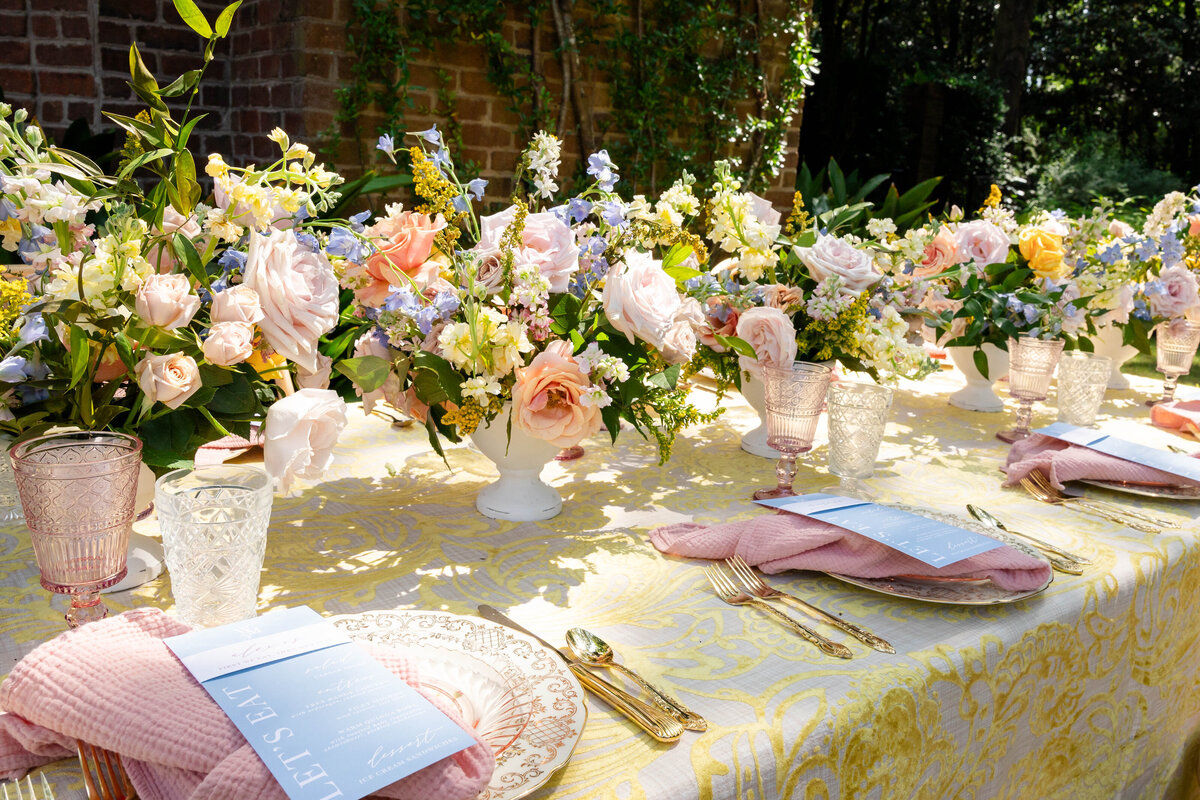 Soft lavendar, peach, pink with light greenery in center of wedding party table.  Place settings in soft gold and peachy pink.