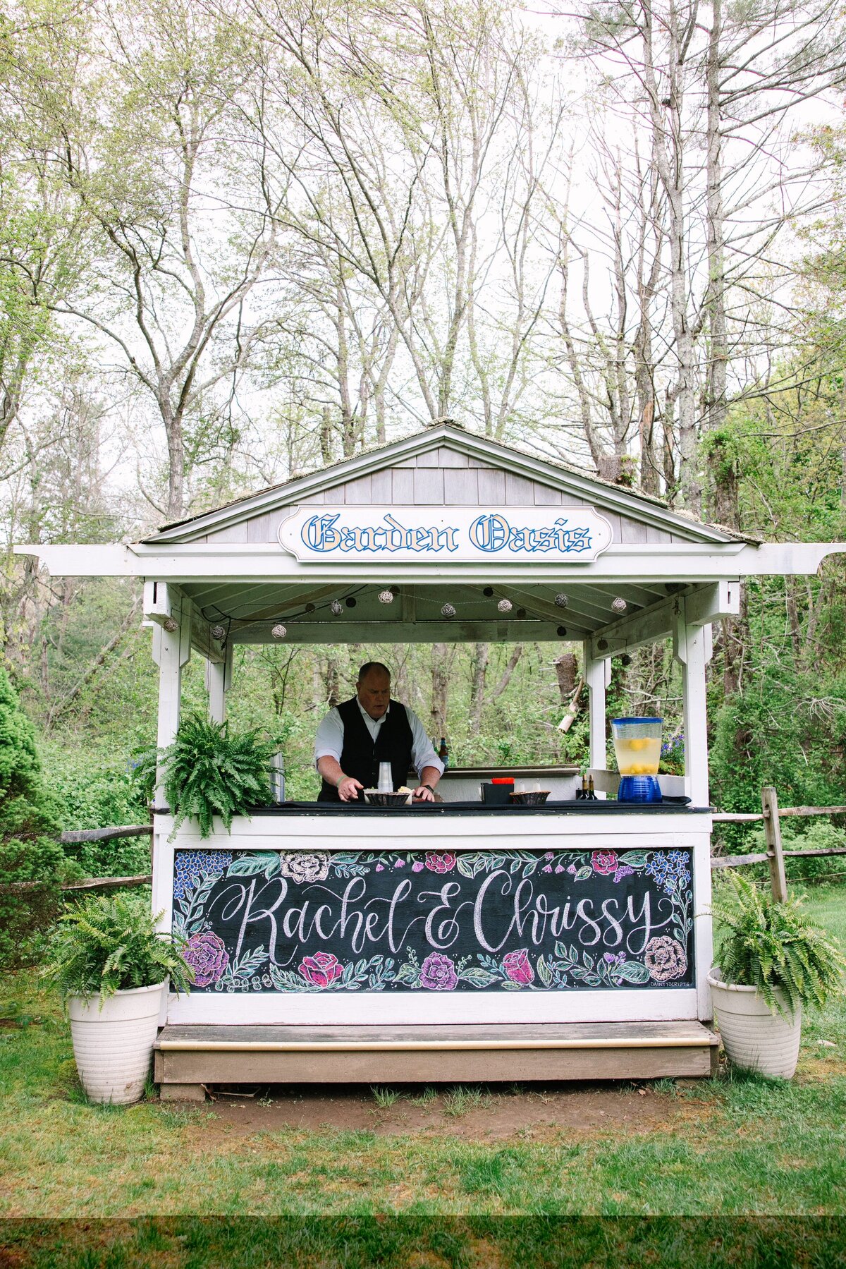 Wedding bar with a chalkboard sign that says "Rachel & Chrissy"