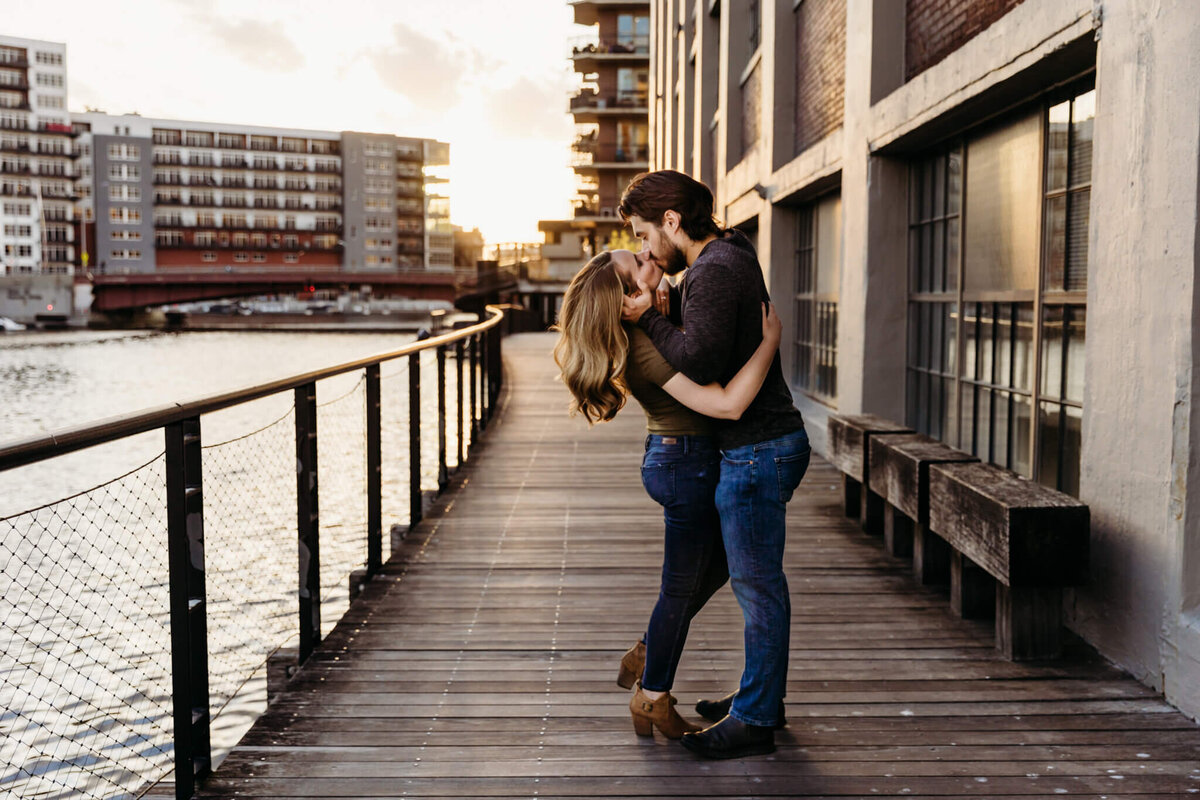 beautiful couple kissing on the boardwalk downtown Milwaukee by Ashley Kalbus