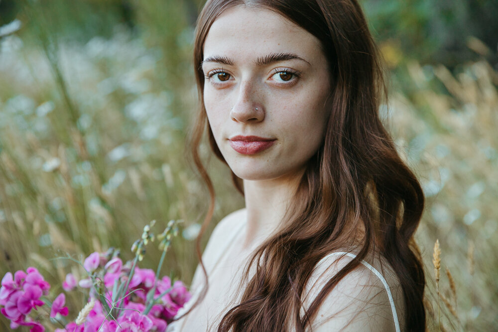 Close up portrait of a graduating high school senior girl in a field of flowers