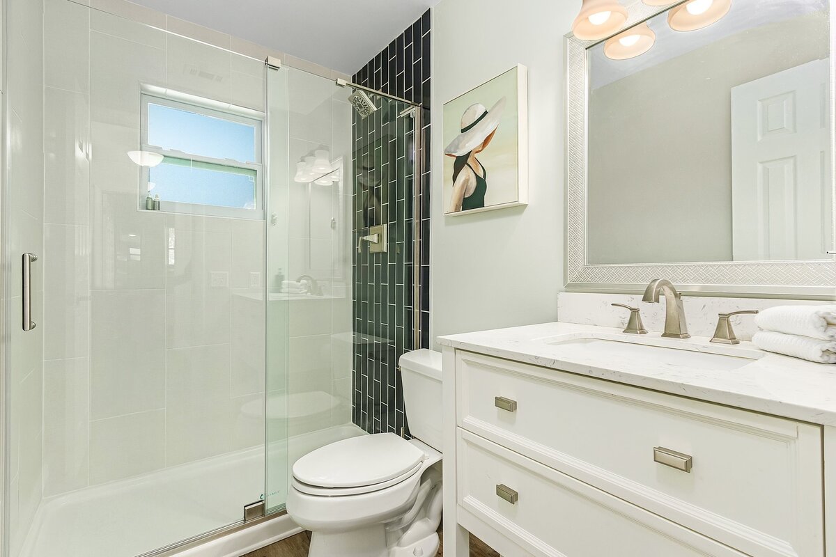 short term rental bathroom with green tile and white sink