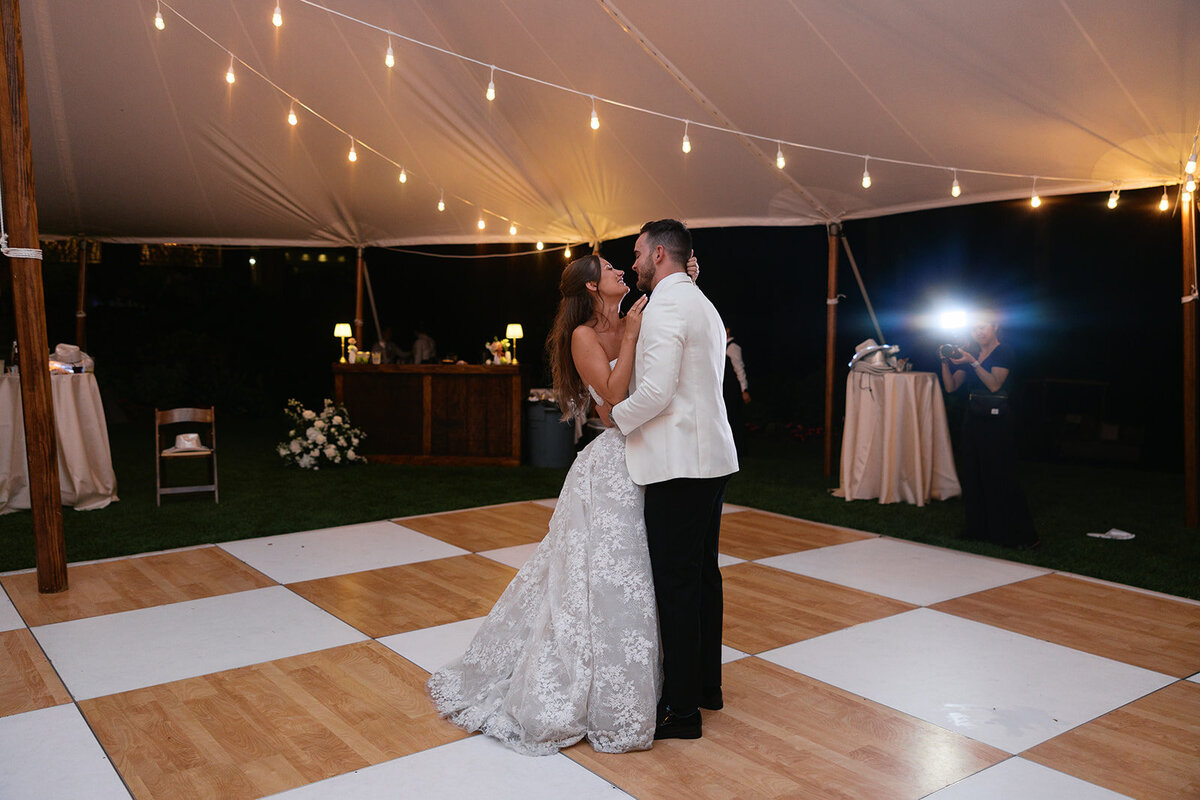 Bride and groom share their private last dance under a sailcloth tent with string lights during their Highlands, North Carolina wedding reception.