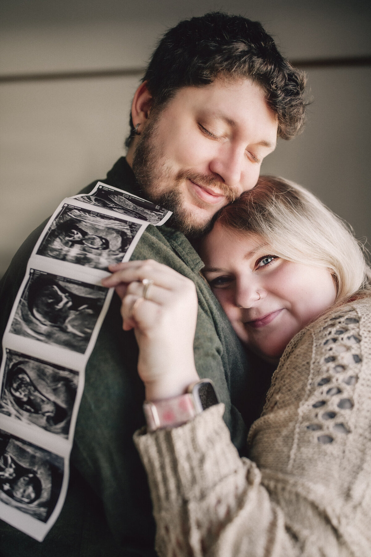 couple holding ultrasound images