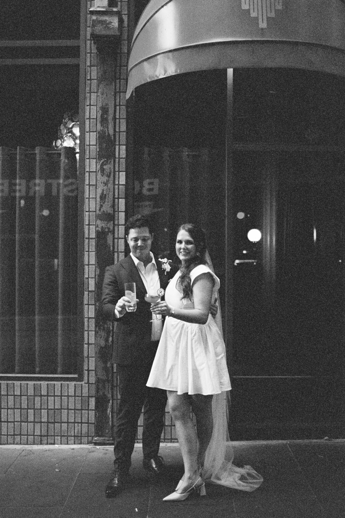 couple standing outside their wedding reception at Bar Jayda in Melbourne CBD on black and white 35mm film