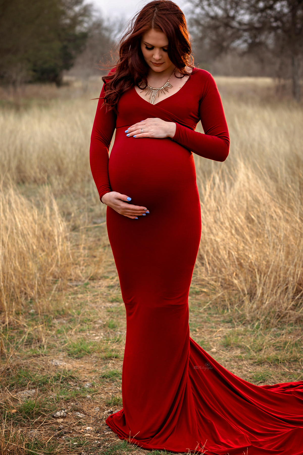 Create winter field dreams with our maternity and family session near San Antonio. Laid-back parents, our mom-to-be's scarlet flying dress adds love and warmth to your family portraits.