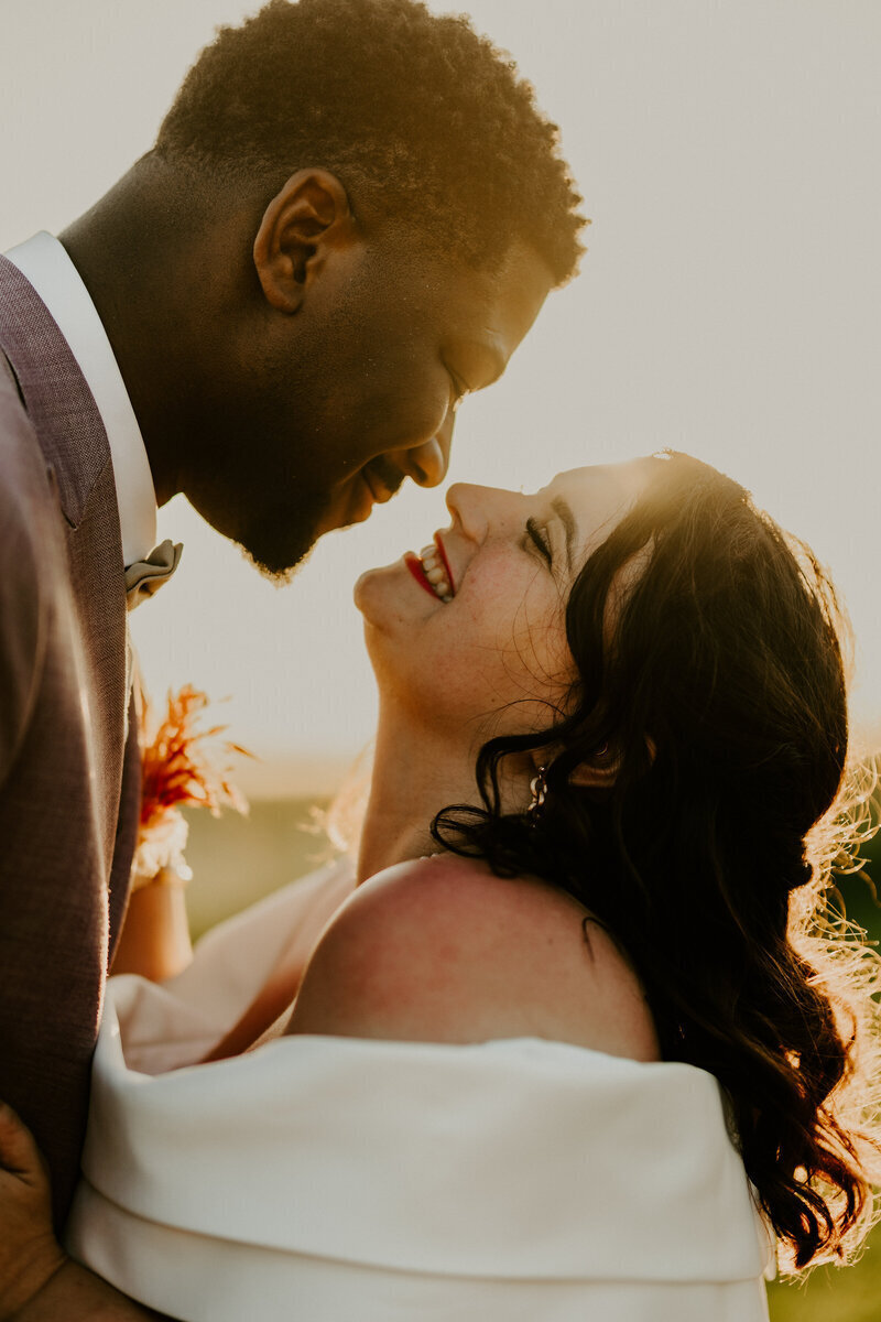 Mariés yeux dans les yeux dans la lueur d'un coucher de soleil immortalisés lors d'une séance photo de mariage en vendée.