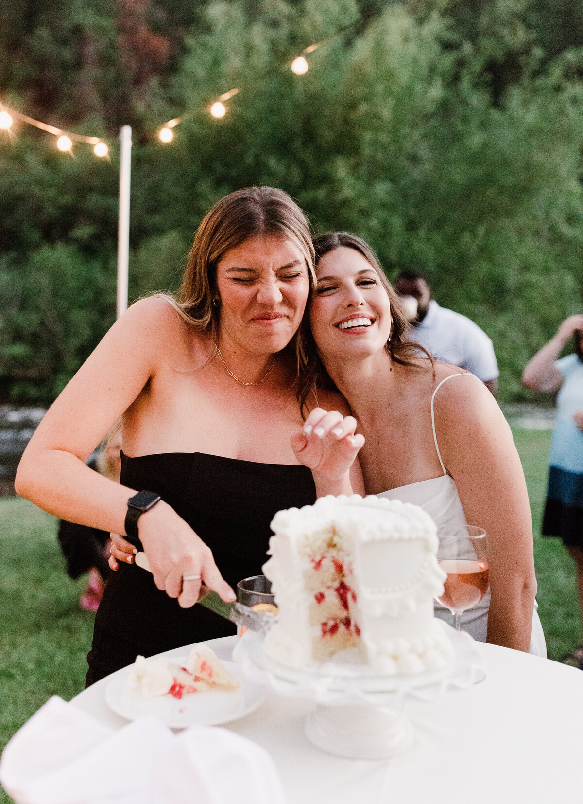 Woman cutting wedding cake at Dallenbach Ranch Wedding reception Colorado