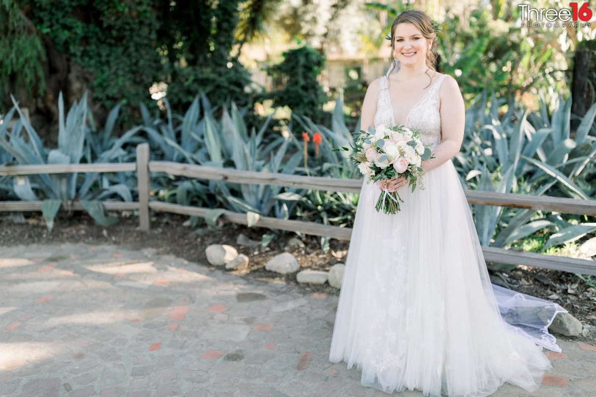 Bride poses near a ranch-style fence