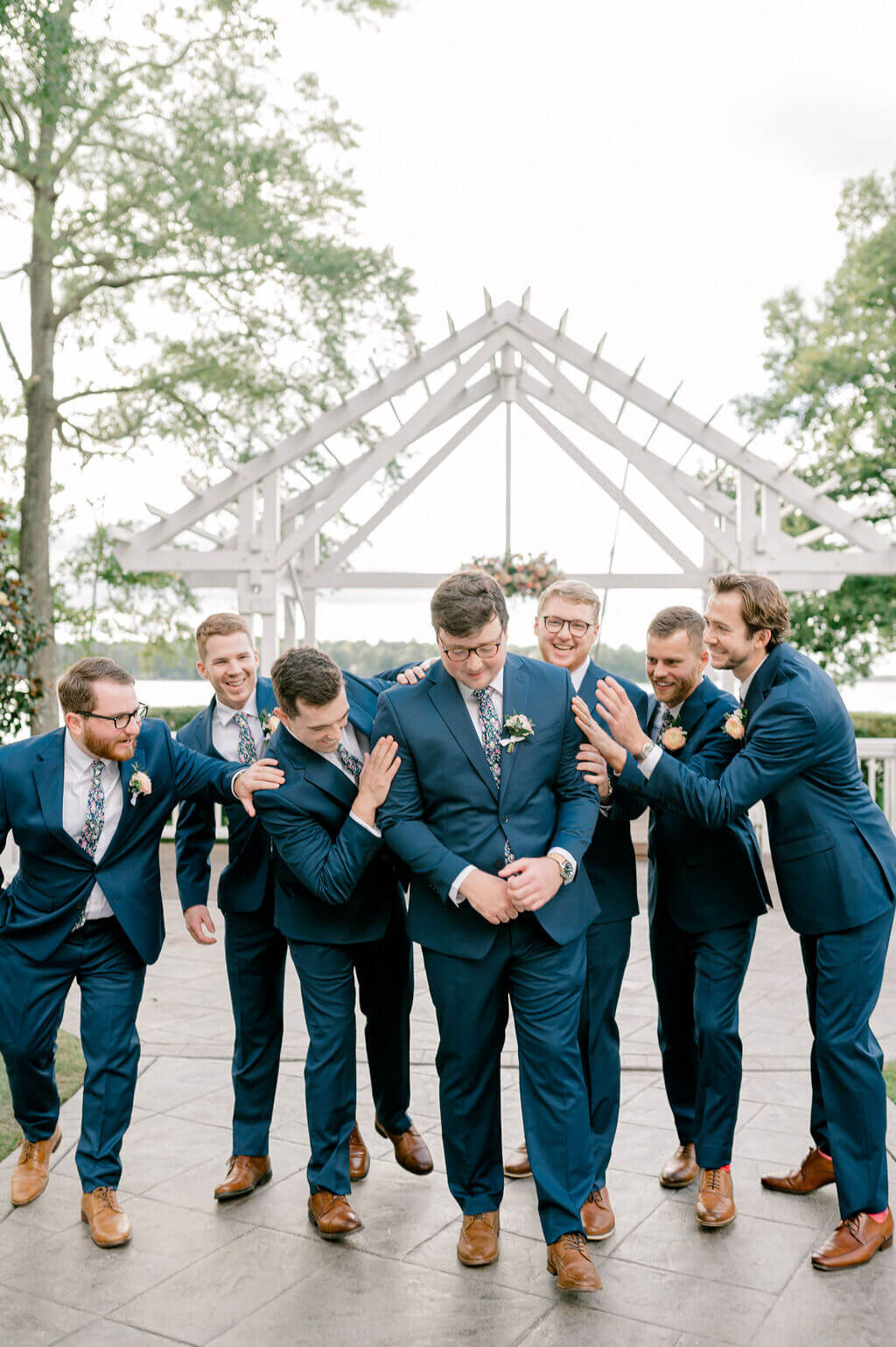 Groom and his groomsmen messing around with one another during groomsmen portraits