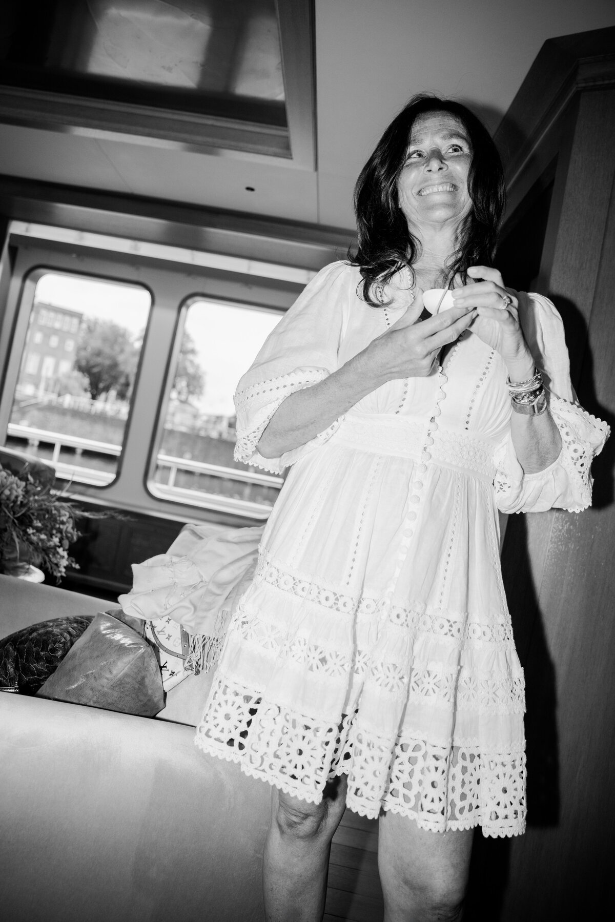 A radiant guest in a chic white dress exudes happiness while enjoying a luxurious event aboard the Samadhi yacht. This photo captures the joyful atmosphere of high-end social gatherings.